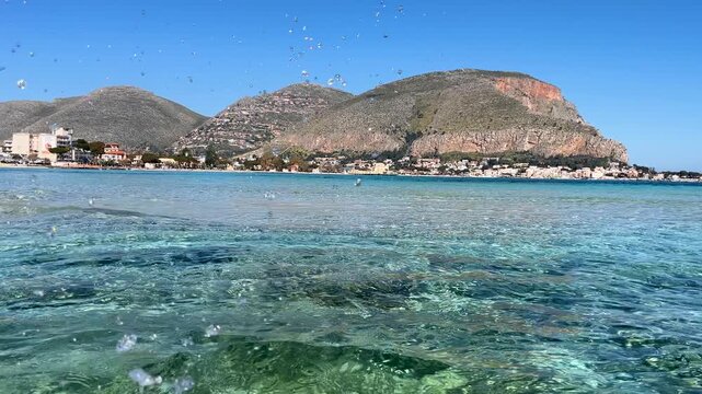 Crystal clear turquoise water flowing near mondello beach in sicily