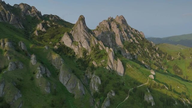 Spectacular conglomerate erosion towers of Tigaile Mari peak in the Ciucas Mountains during golden hour, high altitude aerial forward flight, graded