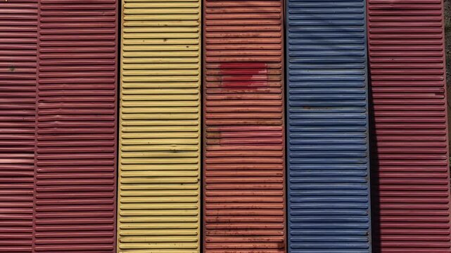Aerial view of stacked shipping containers displaying a spectrum of colors, creating a textural mosaic of industrial storage, Setubal, Portugal.