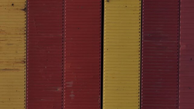 Aerial view of red and yellow patterned shipping containers, contrasting textures and tones creating a visually interesting landscape, Setubal, Portugal.