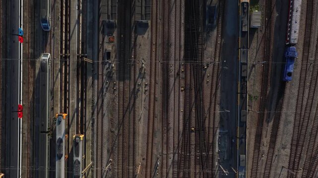 Aerial view of train tracks with parked trains, a symphony of metallic textures and shadows, creating an industrial landscape, Porto, Portugal.