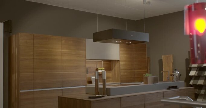 Modern luxury kitchen interior with wood cabinets and black island extractor hood in a showroom