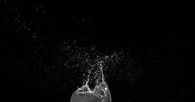 A stunning display of water drops splashing vividly after a heavy object falls, captured in high definition against a dark background. Ideal for dynamic motion graphics design and animation