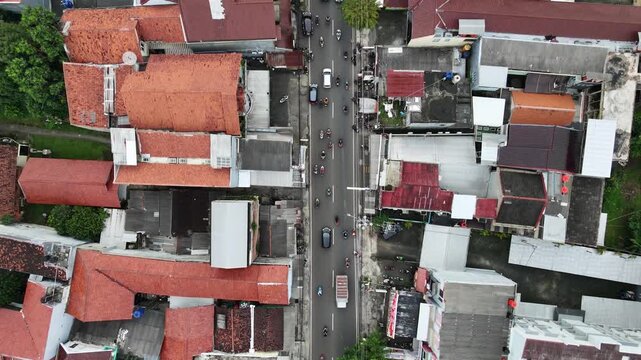 Aerial top down view of a dense residential area with red roofs and narrow street.