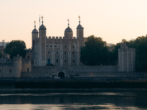 London, United Kingdom - 20 June 2025: View of the historic Tower of London, a fortress bathed in the soft glow of the setting sun, its ancient stone walls reflecting light.