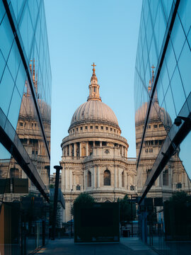 London, United Kingdom - 21 June 2025: View of St. Paul's Cathedral, its dome piercing the sky, framed by modern glass buildings reflecting the soft light of the evening sun.