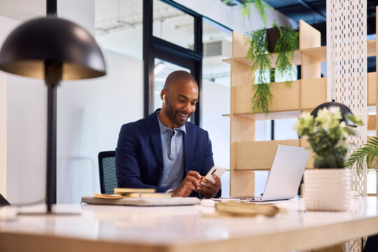 African businessman working on smartphone at office