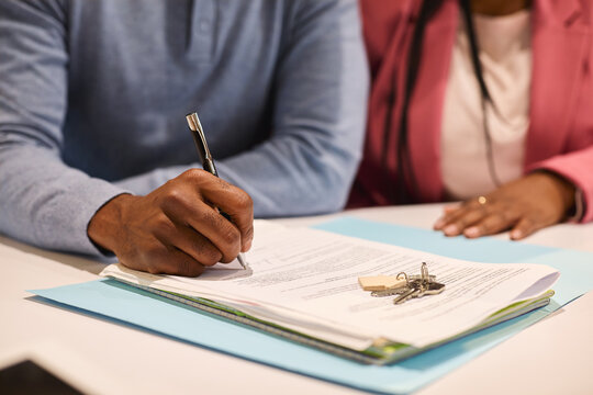Close up of black man hand signing real estate contract agreement