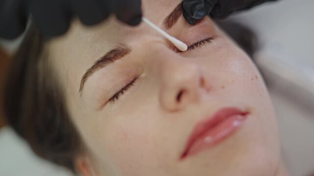 Applying nourishing solution during eyelash lamination treatment