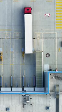 Aerial view of truck loading dock at distribution center. Vertical video.