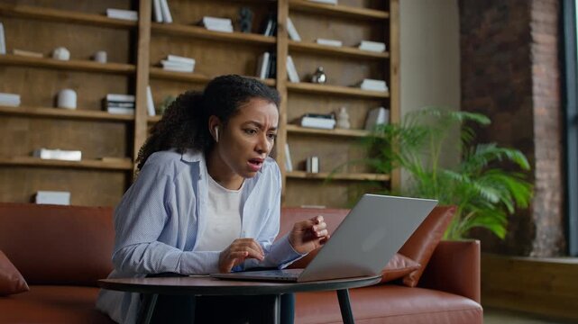 Shocked woman reacting to laptop at home