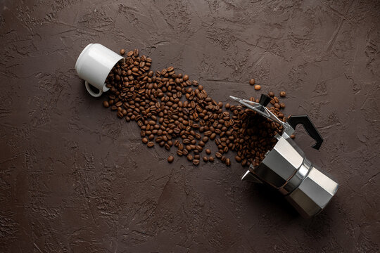 Geyser coffee maker with white cup and coffee beans on brown stone background, top view. Food concept photo