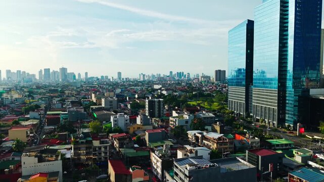 Drone view flying forward along glass skyscraper, warm evening light Makati city