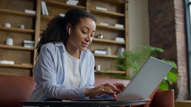Smiling student working on laptop at home