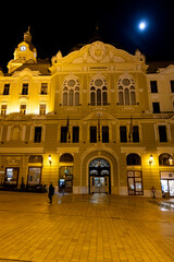 Obraz premium Pecs city hall building illuminated at night under moonlight