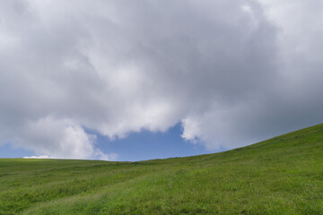 Obraz premium Green pasture land against sky
