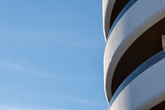 Minimal copyspace sky frames modern architecture as building facade curvature and abstract lines shape a quiet geometric composition