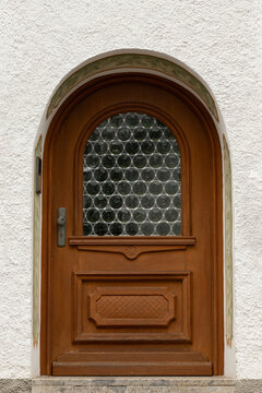 Arched wooden door with circular glass block window