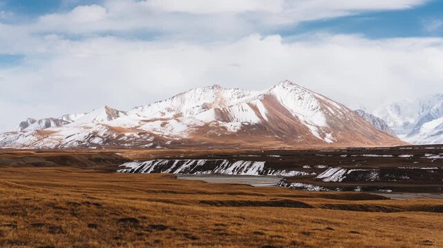 Landscape of Sary Jaz valley with Tian Shan mountain range on golden grassland in autumn at Kyrgyzstan