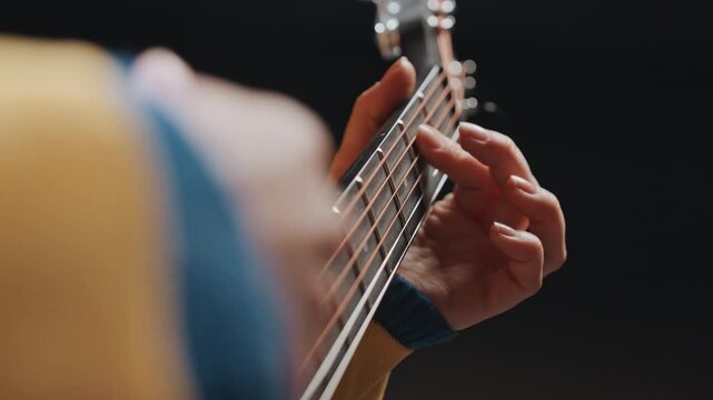 Closeup acoustic guitar melodic picking with gentle finger movements, warm studio light, singersongwriter rehearsing emotive lead lines, focused reflective mood and subtle phrasing