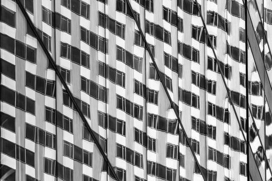 Monochrome modern architecture showing building facade with grid windows pattern and abstract texture creating a graphic editorial mood backdrop