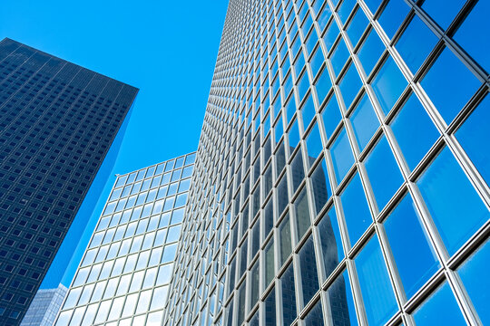 Upward view of facade pattern on glass skyscraper architecture in Paris La Defense capturing corporate office finance business rhythm and geometry