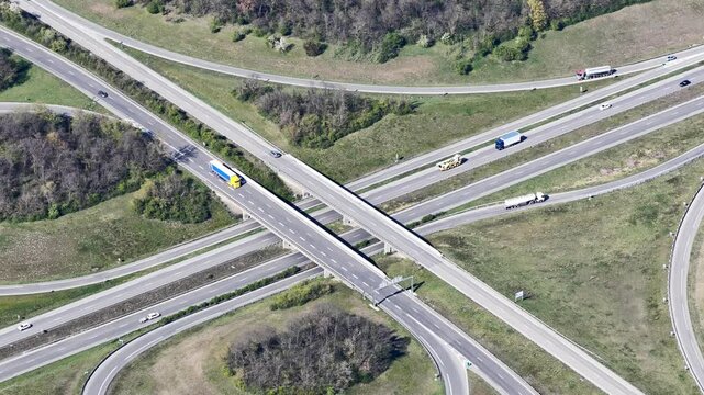 Aerial view of an intricate highway intersection with vehicles flowing seamlessly across multiple lanes amidst green fields, Sausheim, Grand Est, France.
