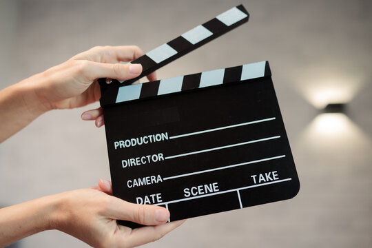 Hands holding clapperboard, signaling start of film production, cinematic movie making storytelling, industry concept