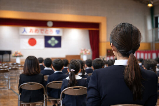 入学式で子どもを見守る母親の視点と学校の風景