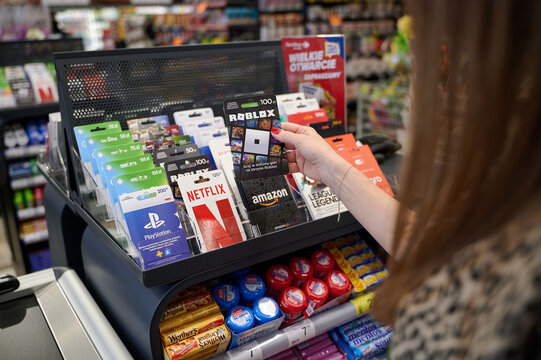 Customer holding a Roblox gift card at a supermarket checkout counter, NoVa Park, Gorzow Wielkopolski, Poland, Europe.
