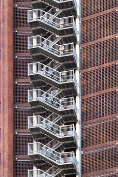 Abstract architecture facade with metal staircase exterior showing geometry pattern and symmetry in urban texture background