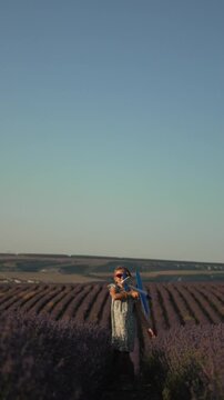 Girl lavender airplane holding a small toy glider plane in a picturesque summer purple field at sunset Vertical video