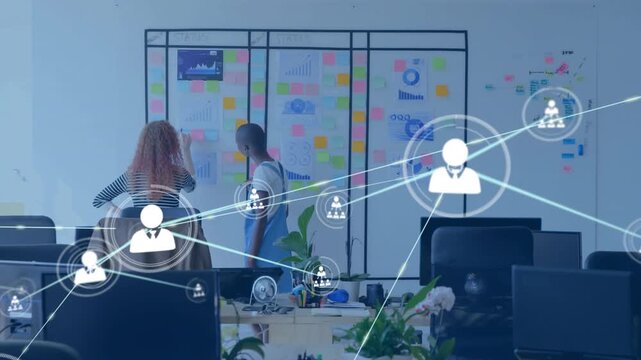 Coworkers pointing and marking at glass wall starting animated tech UI overlay mapping connections
