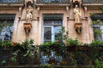 Architecture elements in Toulouse, France. Ornamental details of building - statues of Mary and Jesus Christ. Balcony garden. © Tupungato