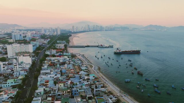 Nha Trang city skyline and traditional fishing port aerial panorama, Vietnam.
the striking contrast between the traditional Lang Chut fishing village and the modern high-rise skyline of Nha Trang.