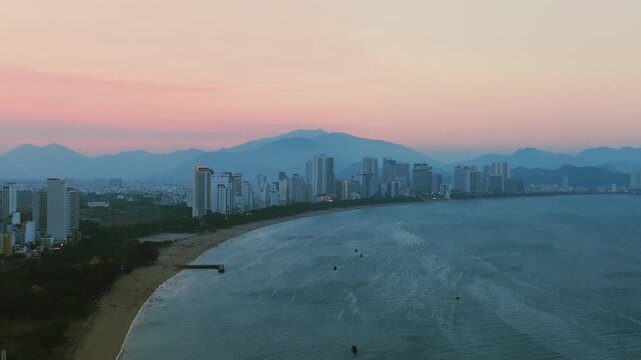 Nha Trang city skyline and traditional fishing port aerial panorama, Vietnam.
the striking contrast between the traditional Lang Chut fishing village and the modern high-rise skyline of Nha Trang.