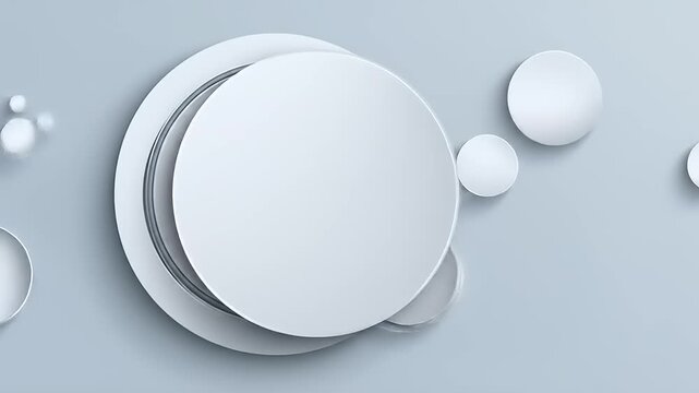 Composition of overlapping white circular shapes with recessed detailing against a light gray background