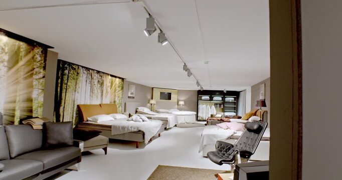 Modern bedroom furniture showroom with various bed designs, lighting, and decorative forest wall murals