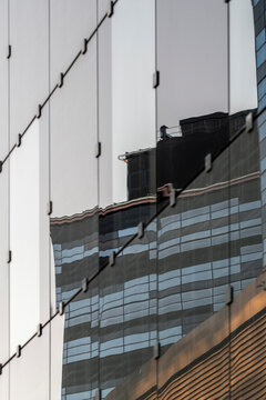 Abstract modern glass facade where reflection and distortion reshape architecture lines on the building exterior creating striking detail