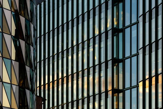Abstract detail of modern glass facade where lines and stripes shape a reflective architecture pattern across the building exterior in close view