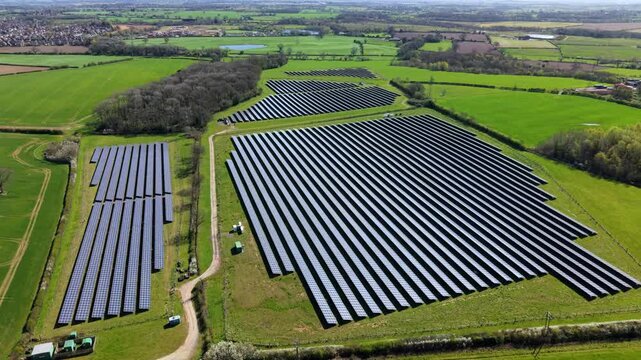 Top down aerial view of a massive solar farm with photovoltaic panels in the UK countryside