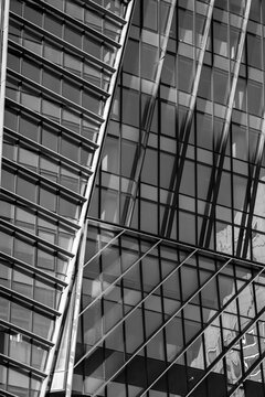 Modern monochrome architecture facade with abstract glass structure and diagonal lines across grid creating dynamic geometric pattern for design detail