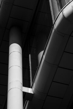 Industrial monochrome architecture abstract with geometric columns pipes and metal structure lines creating strong modern infrastructure detail and texture