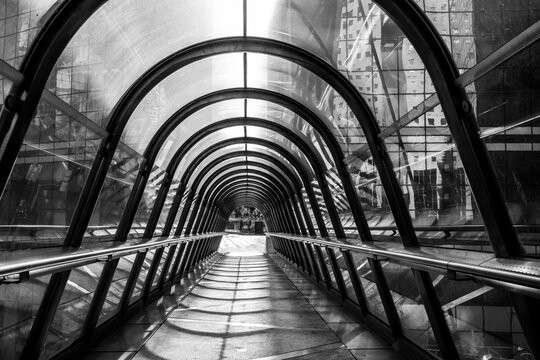 Modern monochrome architecture walkway tunnel with abstract arches showing symmetry perspective and leading lines for clean urban passage design detail