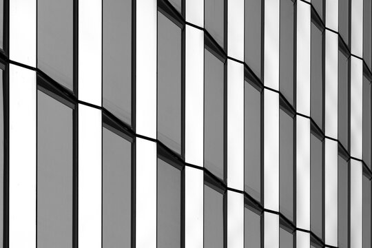 Abstract architecture facade with geometric stripes pattern on glass grid lines in crisp monochrome style for modern urban design detail