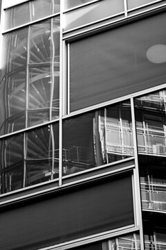 Modern monochrome architecture building with abstract geometric glass reflections showing windows and strong lines for sleek corporate facade detail