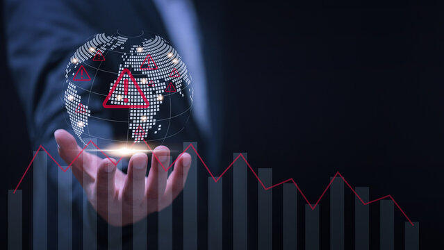 Serious professional man holding digital earth with red warning sign displaying alarming global economic crisis and instability concept