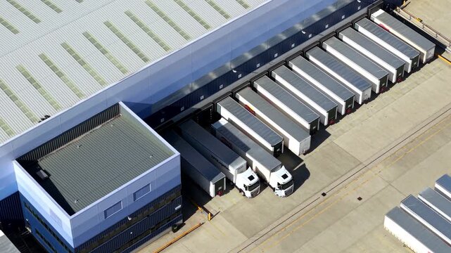 Top down aerial view of rows of HGVs lined up in bays at logistics distribution centre in Magna park UK