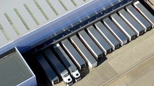 Top down aerial view of rows of HGVs lined up in bays at logistics distribution centre in Magna park UK