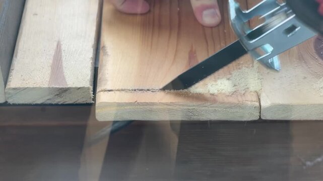 The video shows the process of creating a precise groove or chamfer on a wooden workpiece using a DIY cutting tool.